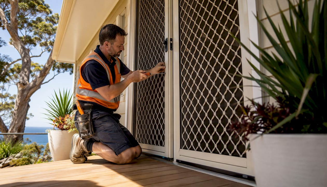 Tradesperson installing double security screen door