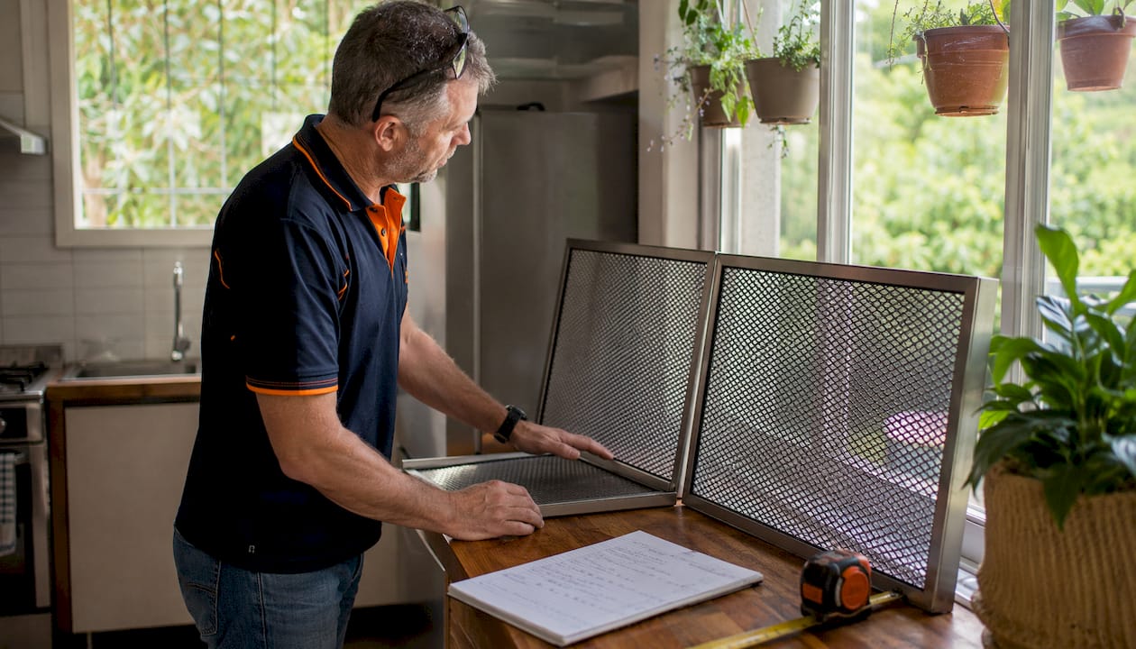 Man inspecting Crimsafe and Invisi-Gard security screens